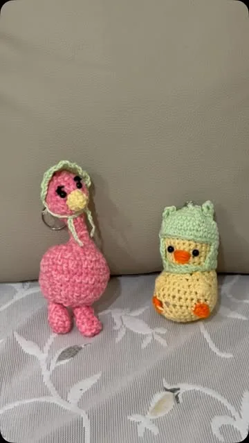 Pink flamingo and yellow duckling crochet keychains side by side
