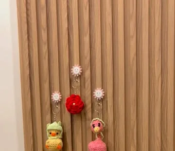 Mini flower and animal keychains hanging on a wooden wall