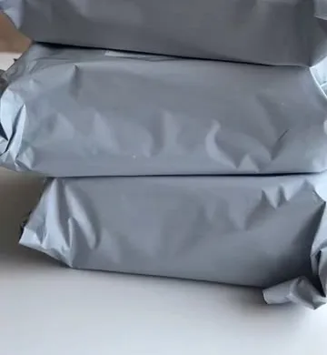 Stack of grey shipping pouches packed with orders